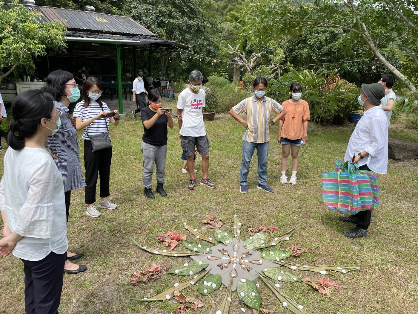 110 年農業療育活動試辦：學員圍成一圈，看著草地上的花葉曼陀羅