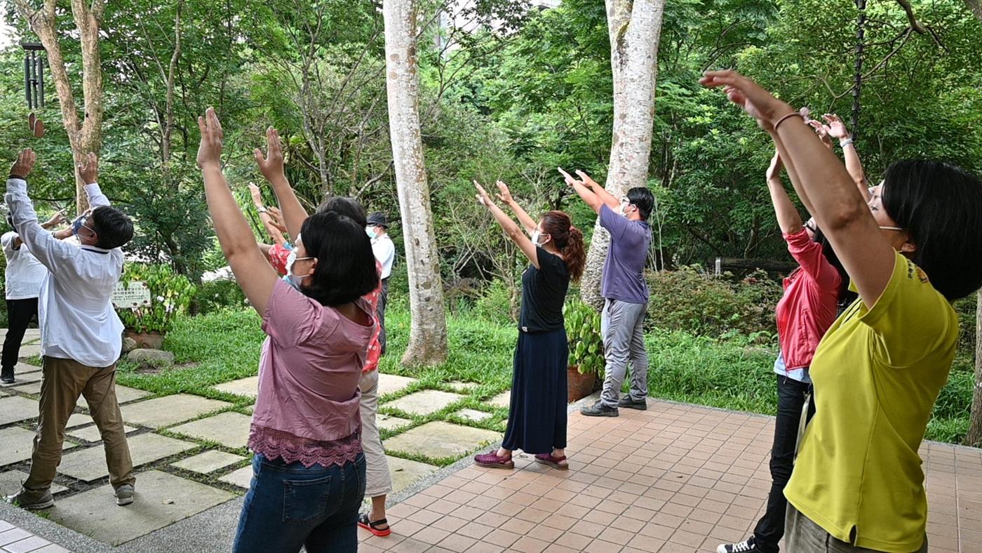 農業療育士培訓學員在庭園裡伸展身體